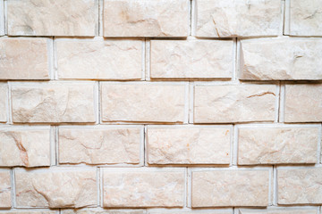 Light beige wall made of decorative bricks.