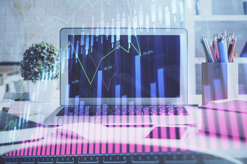 Forex market chart hologram and personal computer background. Double exposure. Concept of investment.