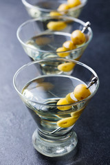 Martini cocktail with olives. Dark background. Close up.