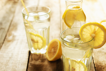 Preparation of the lemonade drink. Lemonade in the jug and lemons with mint on the table outdoor