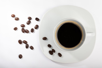 Fototapeta premium White cup with coffee on a white background and coffee beans