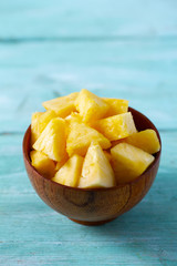 fresh pineapple pieces on wooden surface