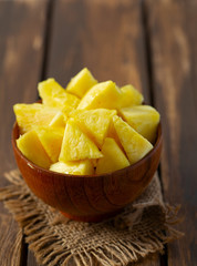 fresh pineapple pieces on wooden surface