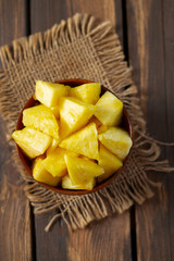 fresh pineapple pieces on wooden surface