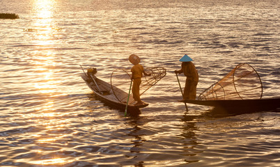 Silhouette of Traditional Burmese fishermen lifestyle on sunset, sunrise time at Inle lake, Myanmar...