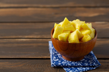 fresh pineapple pieces on wooden surface