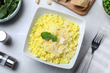 Delicious risotto with cheese on grey marble table, flat lay