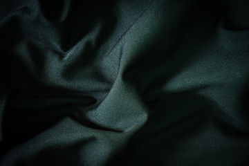 Black luxury cloth, Dark gray abstract background. Detail fabric of pattern grunge silk texture satin velvet material or luxurious. Crumpled textile shiny black color. Design, elegance with vignette.