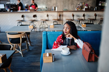 Сonfident young african american woman in smart casual wear at cafe.