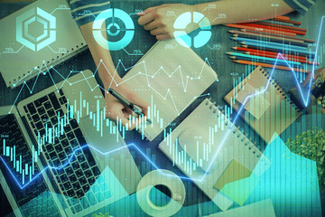 Financial chart drawn over hands taking notes background. Concept of research. Double exposure