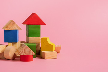 Children's wooden toys on a pink background concept zero west. Small houses the designer from...