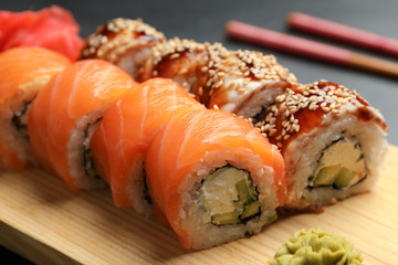 Delicious sushi rolls on wooden tray, closeup