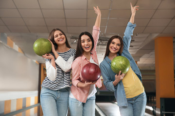 Group of young women with balls in bowling club - obrazy, fototapety, plakaty
