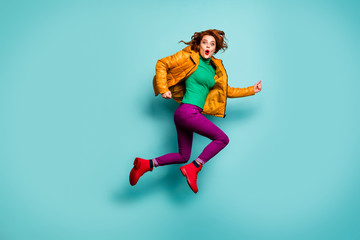 Fototapeta na wymiar Full length photo of funny fast speed lady jump high rush sale shopping center cool prices wear yellow coat scarf magenta pants turtleneck red boots isolated teal color background