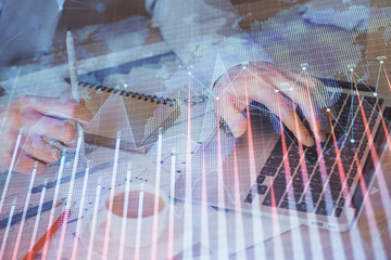Forex graph with businessman working on computer in office on background. Concept of hardworking....