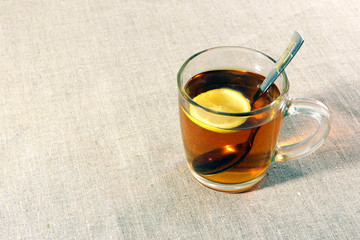 Cup of tea with lemon on a linen fabric.