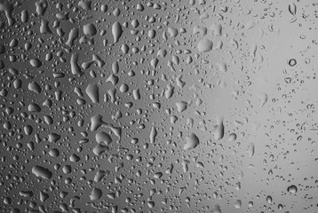 Rain drops on glass against grey background