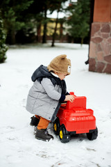 Fototapeta na wymiar Baby boy and toy car in winter