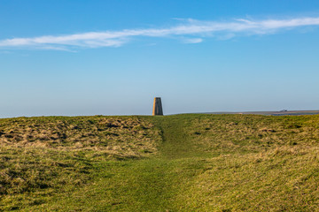 A trig point on Firle Beacon in the South Downs, on a sunny winters day - obrazy, fototapety, plakaty