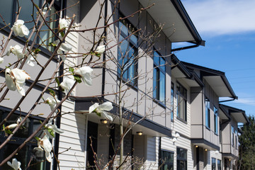 Brand new upscale townhomes in a Canadian neighbourhood. External facade of a row of colorful...
