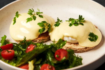 Eggs benedict with bacon meat and fish, close-up