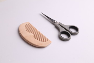 wooden comb and scissors in color background