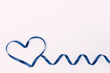 Heart shape made of ribbon on a white background. Tinted fashion classic blue in 2020. Concept of International Women's mother's Day on March 8 and Valentine's day. Space for text. Mockup