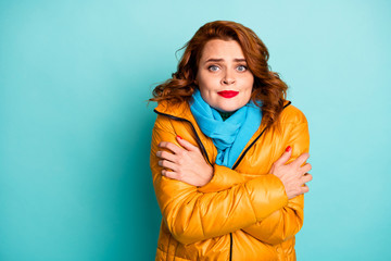 Photo of pretty traveler lady frosty winter day shaking all body walk street hug herself wear trendy casual yellow overcoat blue scarf isolated turquoise color background © deagreez