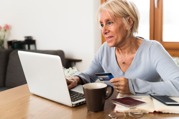 senior smiling woman buying on line with credit card