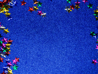 Festive colorful stars on trendy blue background. Holiday abstract flat-lay.