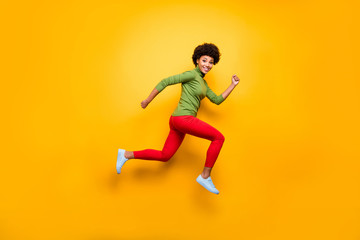 Fototapeta na wymiar Full length body size view of her she nice attractive lovely cheerful cheery funky wavy-haired girl jumping running having fun isolated over bright vivid shine vibrant yellow color background