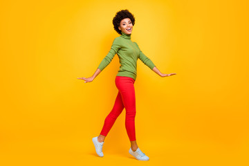 Fototapeta na wymiar Full length body size view of her she nice attractive lovely teenage cheerful wavy-haired girl walking spending free spare time isolated over bright vivid shine vibrant yellow color background