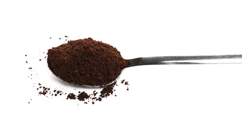 Milled coffee powder for espresso with metal spoon isolated on white background