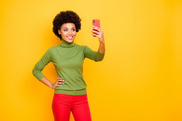 Photo of casual cheerful positive nice pretty sweet girlfriend with hand on waist confident smiling toothily in red pants isolated near empty space over vibrant color background