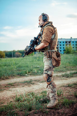 American soldier with the M4 rifle on the ruined town background.