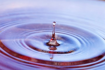 Water drop splashing over the water surface