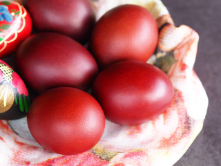 Natural Easter eggs and wooden painted eggs on a napkin close-up. Colorful and bright picture for the spring holiday Easter.