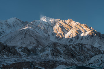 Snow mountain located in Xinjiang China Pamir Plateau in winter season. Pure blue sky and yellow sun light.