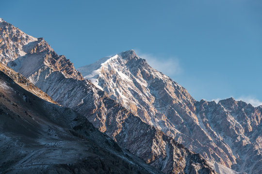 Snow mountain located in Xinjiang China Pamir Plateau in winter season. Pure blue sky and yellow sun light.