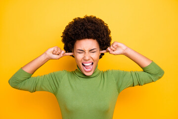 Photo of screaming shouting grimacing girl shutting ears not to hear anything irritated bothered by...