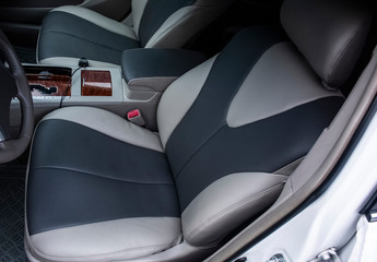 Two seats in the interior of the car tied with dark gray and gray leather