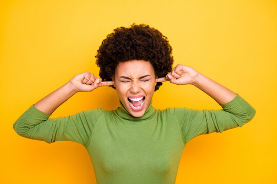 Photo of screaming shouting grimacing girl shutting ears not to hear anything irritated bothered by people surrounding isolated vivid color background