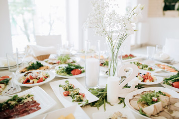 wedding table set for a dinner with food and flowers