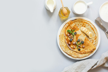 Crepes, thin russian pancakes on blue background. View from above. Space for text.