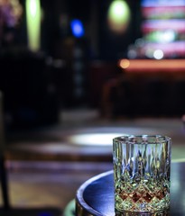 crystal whiskey glass on lounge table near bar counter