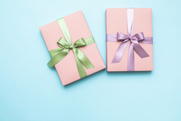 Pink gift box with ribbon and bow on blue background