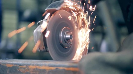 Close up of a rotary saw cutting metal with sparks