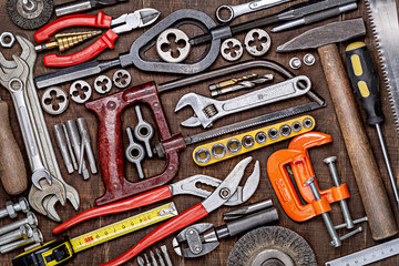 Various metalwork tools for wood and metal processing on a wooden brown background. View from above. Men's style. Father's Day and other men's holidays.