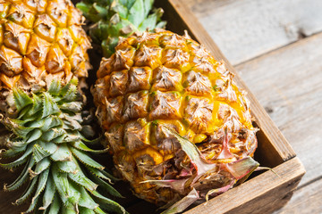 Fresh ripe pineapple in the old wooden crate. Selective focus.