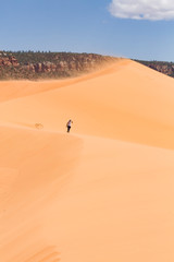 Fototapeta na wymiar Woman in Coral Pink Sand Dunes, Utah